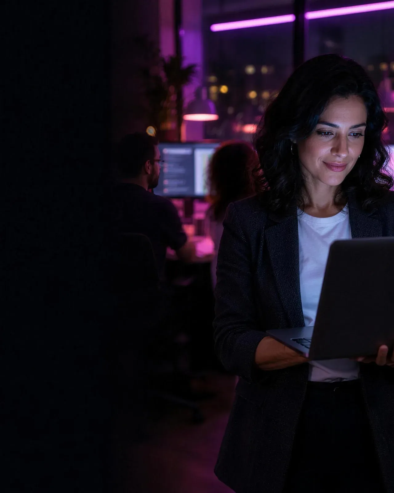 Gestora no escritório à noite, conferindo no notebook o que o time fez com IA
